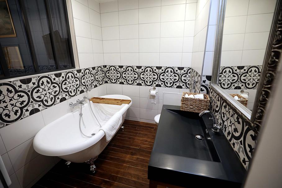 Salle de bain avec baignoire sur pieds et vasque noire