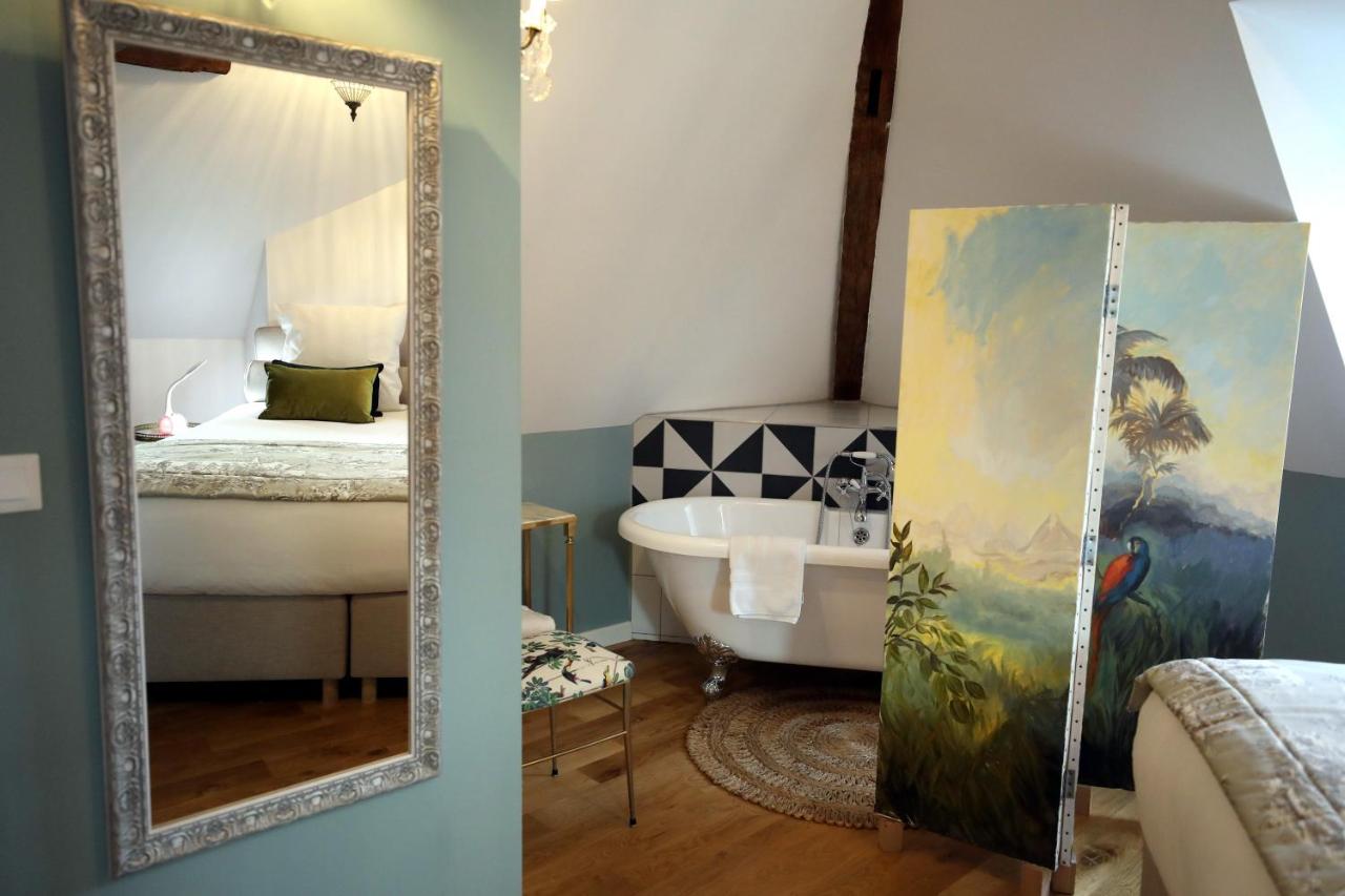 Miroir reflétant la chambre et sa baignoire