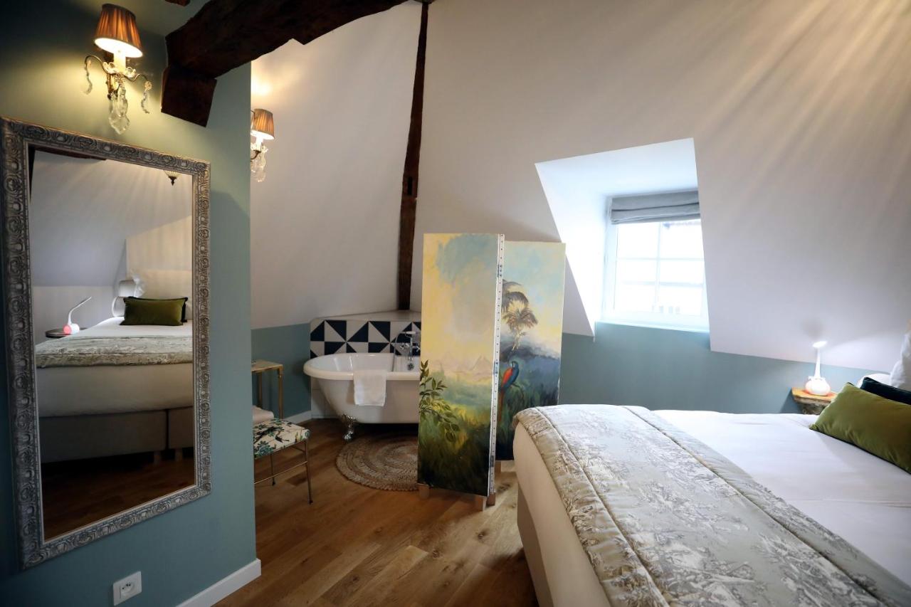 La baignoire installée dans la chambre, derrière le paravent peint