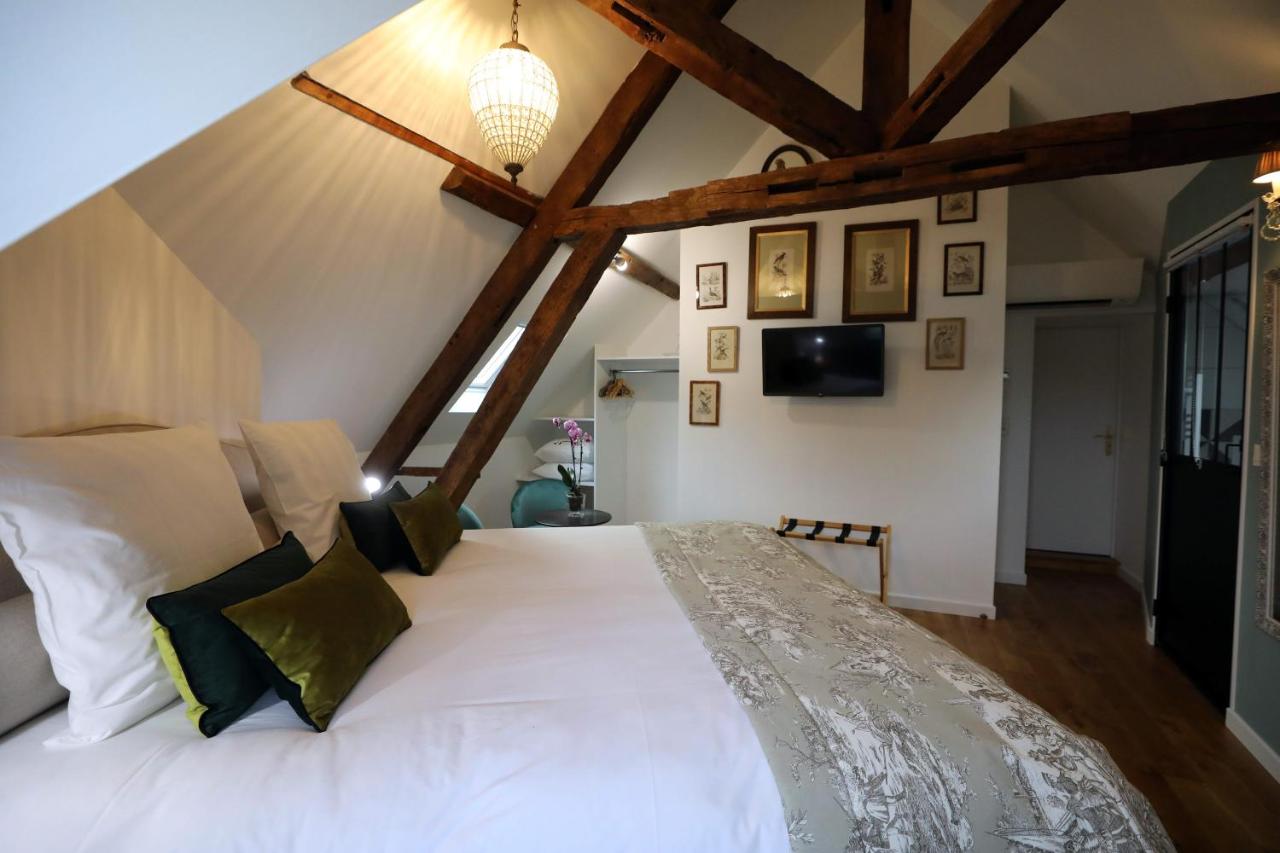 Chambre mansardée décorée de cadres anciens