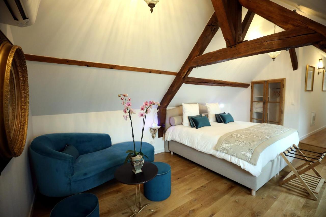 Chambre spacieuse sous charpente, orchidée et coin salon