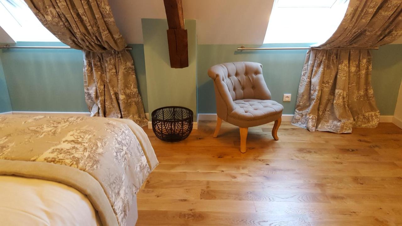 Chambre aux murs vert d'eau, fauteuil et rideaux