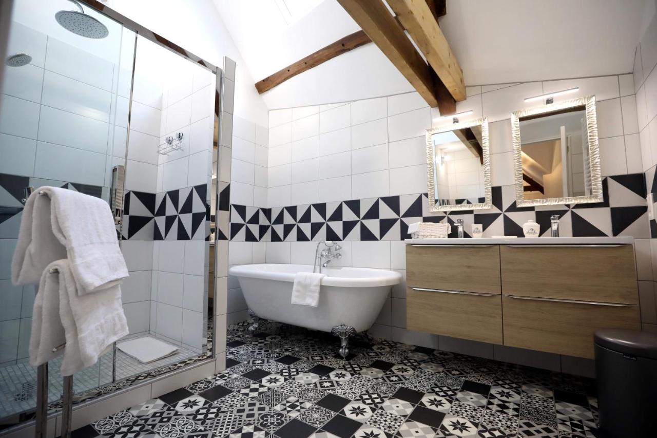 Grande salle de bain avec douche, baignoire et double vasque
