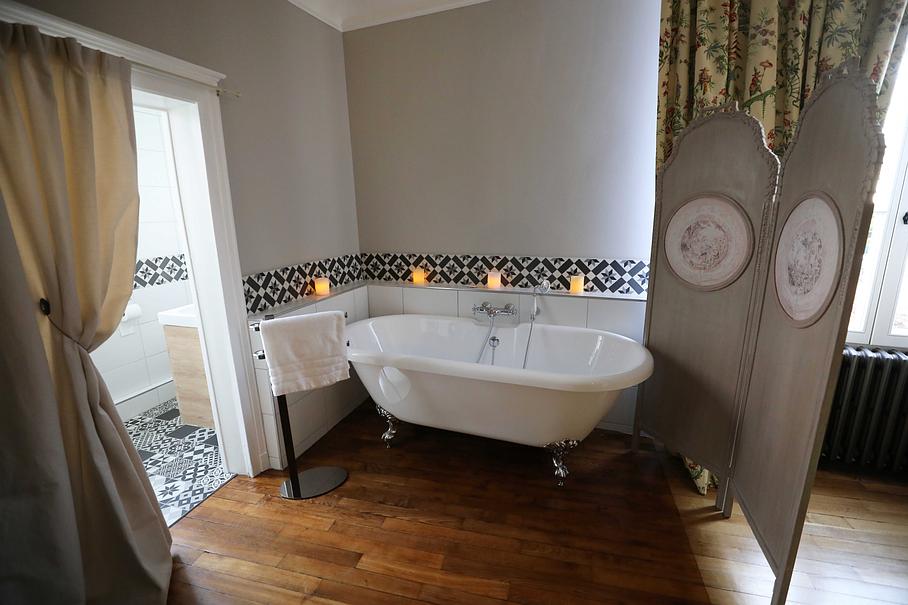 Baignoire sur pieds derrière un paravent