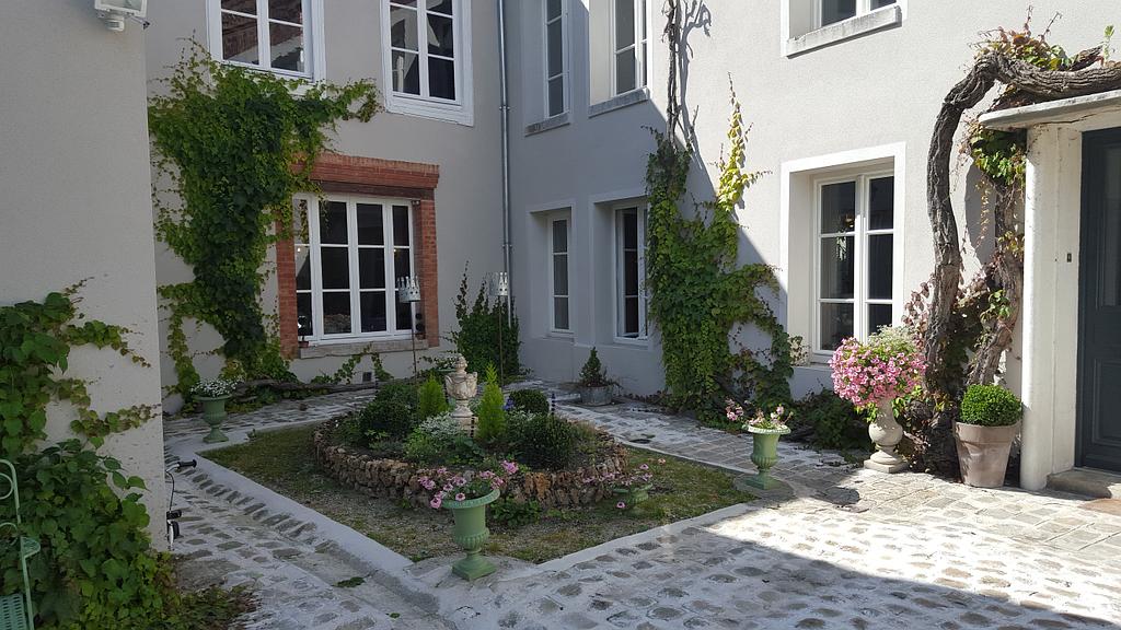 La cour pavée et son jardin fleuri