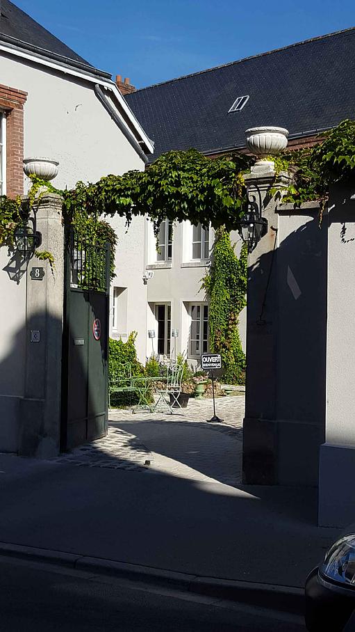 L'entrée de la demeure et sa cour pavée