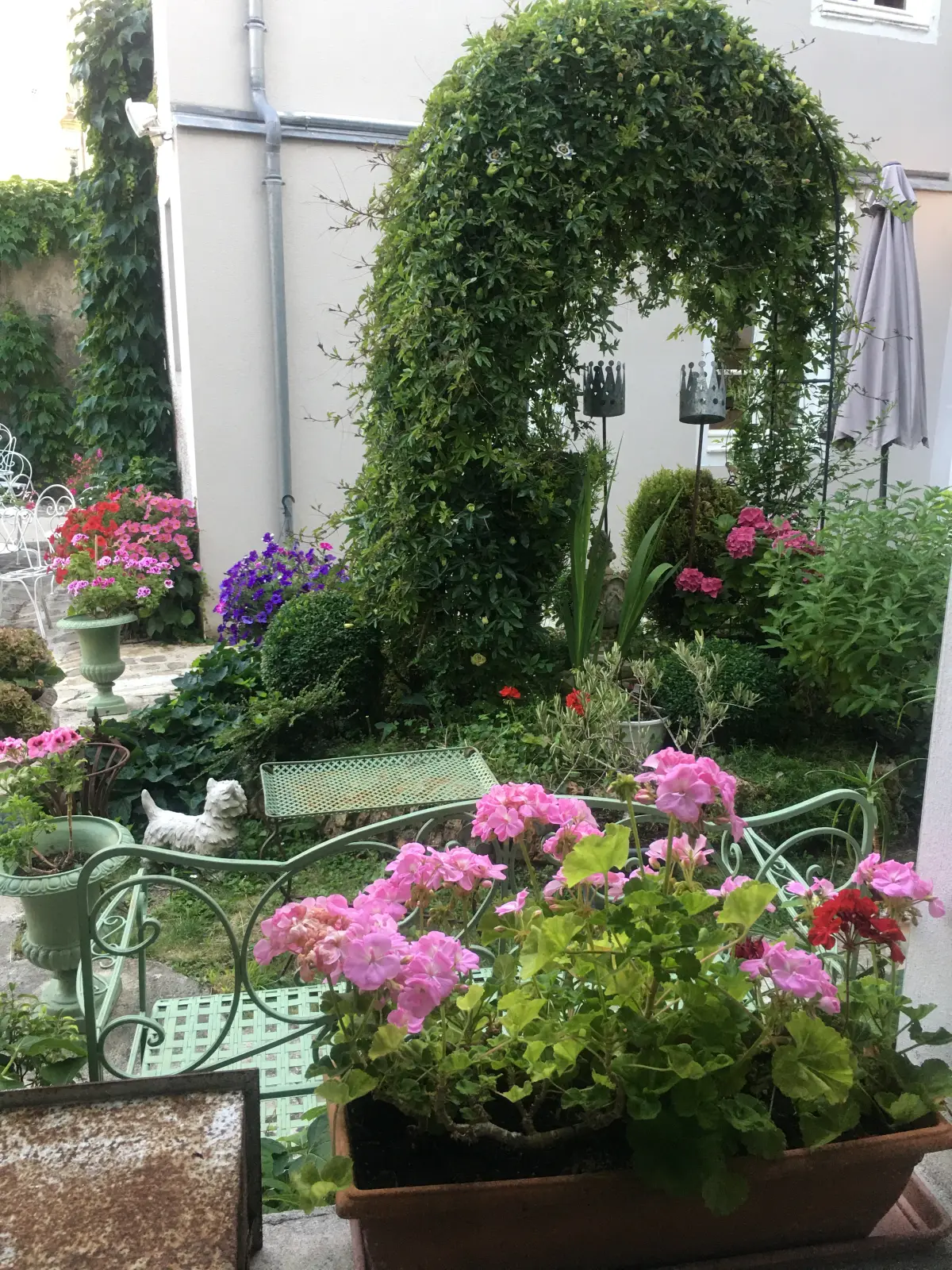 Parterre fleuri, vasques et banc de jardin